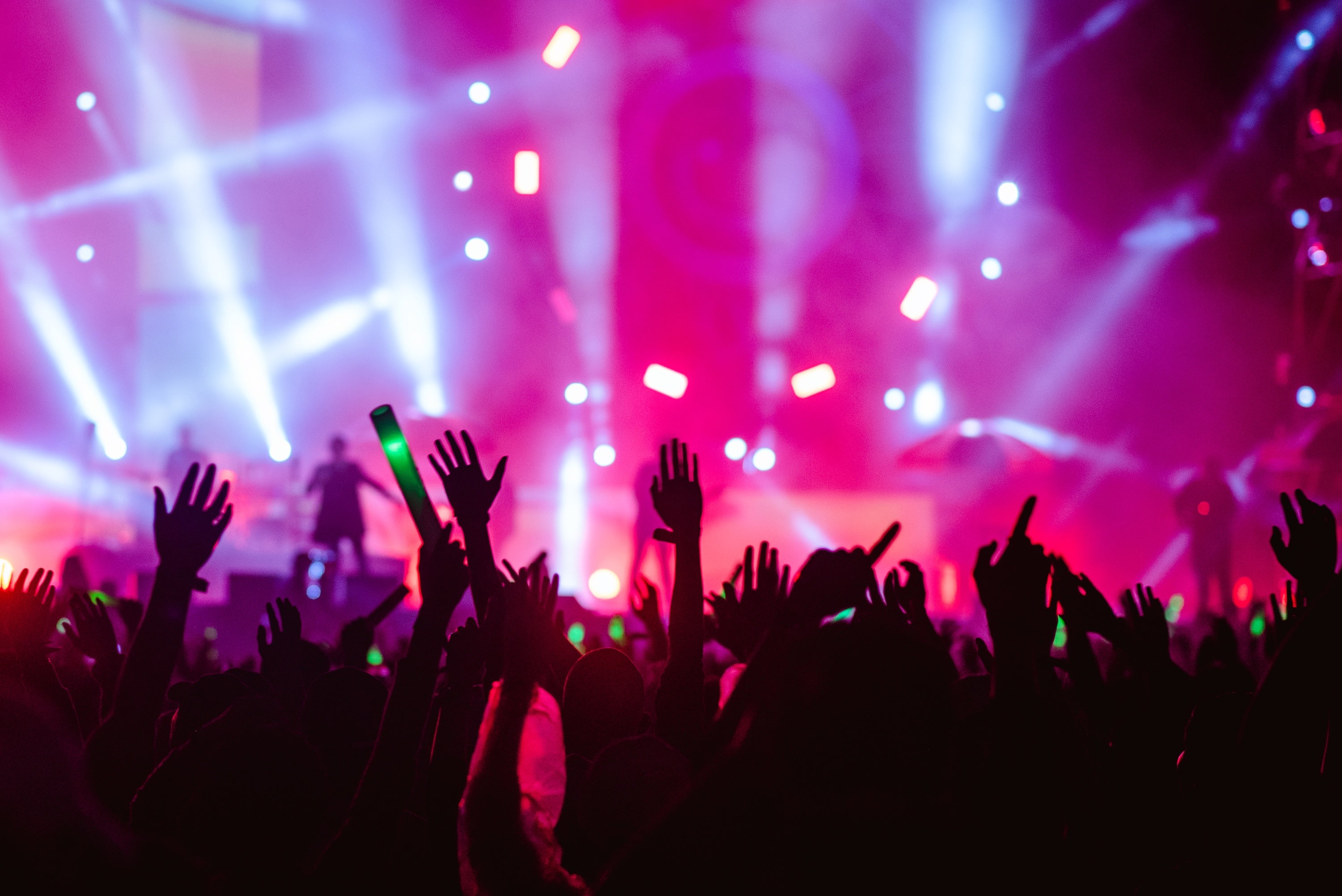 Live concert with audience cheering and band on stage with lighting